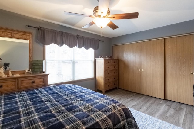 bedroom with ceiling fan, light hardwood / wood-style floors, and a closet