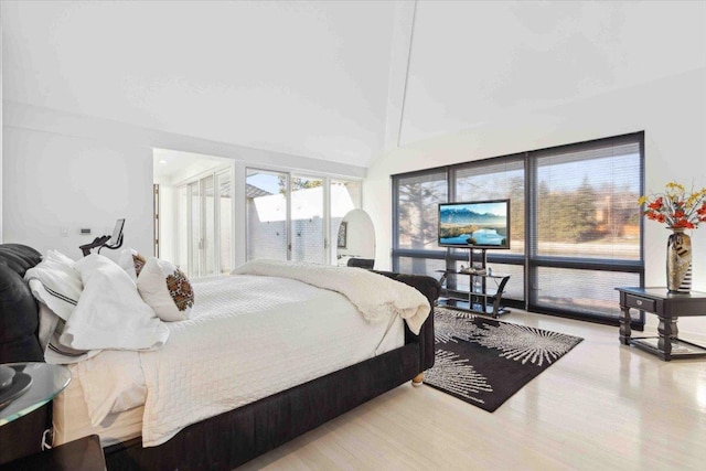 bedroom with a towering ceiling and light hardwood / wood-style flooring