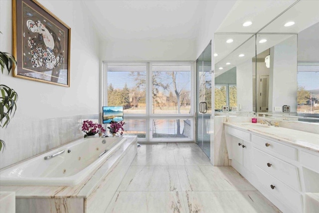 bathroom featuring vanity and tiled bath