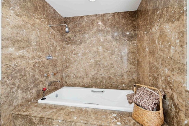 bathroom with a relaxing tiled tub and tile walls