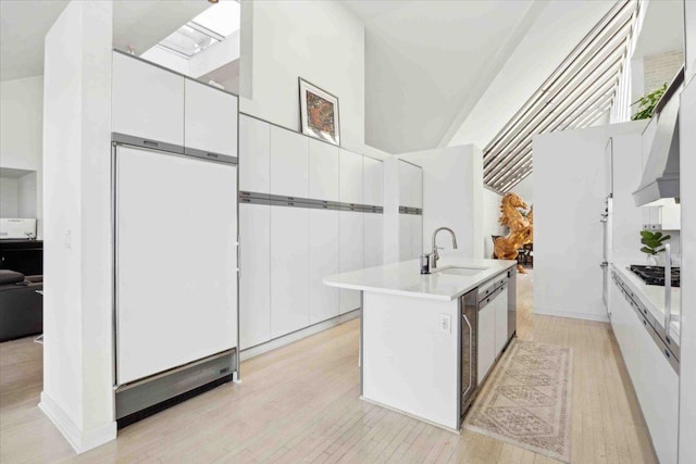 kitchen with an island with sink, white cabinetry, stainless steel gas stovetop, and sink