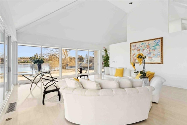 living room featuring beamed ceiling, a water view, high vaulted ceiling, and light hardwood / wood-style flooring