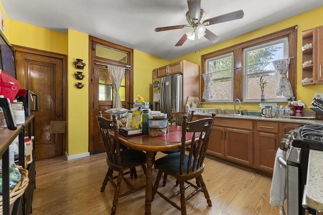 dining area featuring light hardwood / wood-style flooring, ceiling fan, and sink