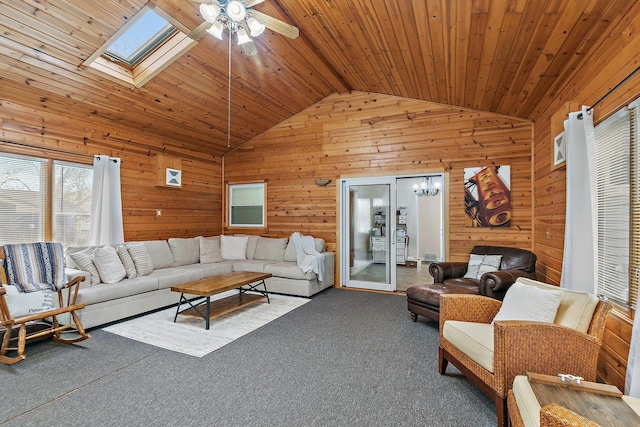 carpeted living room with a skylight, ceiling fan, wooden walls, and wood ceiling