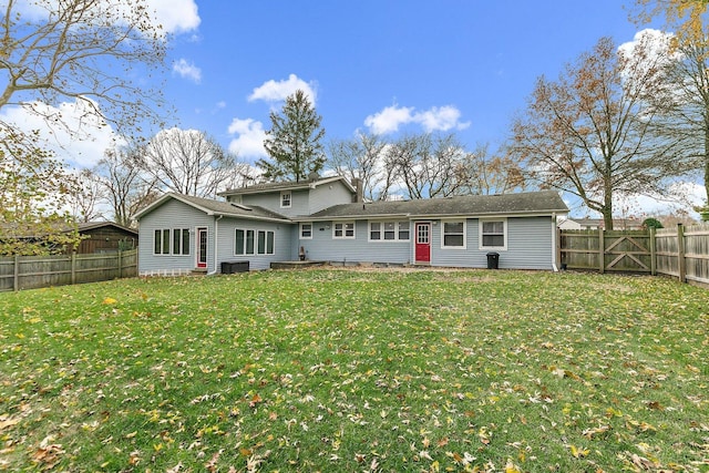 rear view of house with a lawn and cooling unit