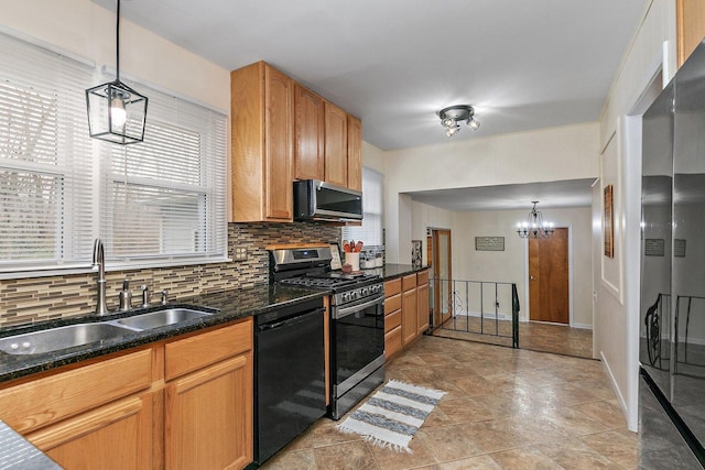 kitchen featuring appliances with stainless steel finishes, decorative light fixtures, tasteful backsplash, and sink