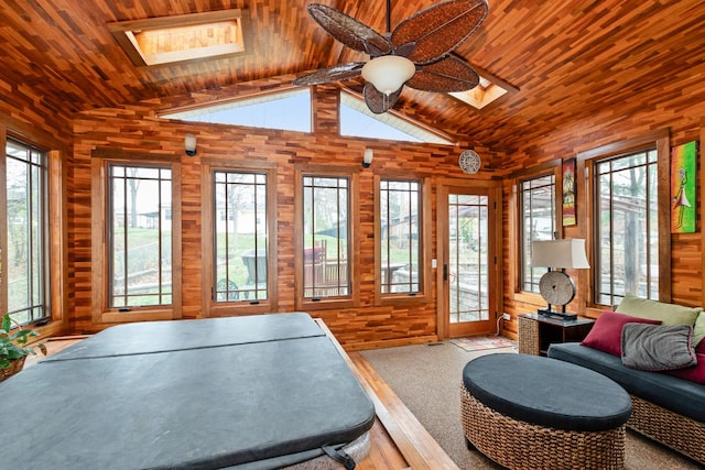 interior space with ceiling fan, lofted ceiling with skylight, and wood ceiling