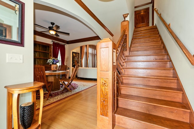 stairway featuring ceiling fan, hardwood / wood-style flooring, and ornamental molding