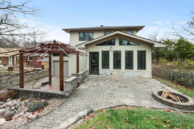 rear view of property with a fire pit and a patio area