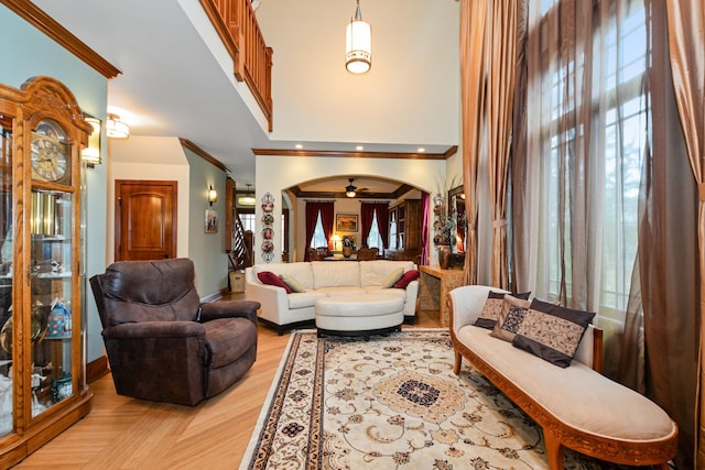 living room with ceiling fan, light wood-type flooring, and ornamental molding