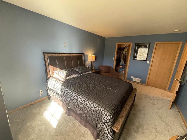 carpeted bedroom featuring a walk in closet and a closet