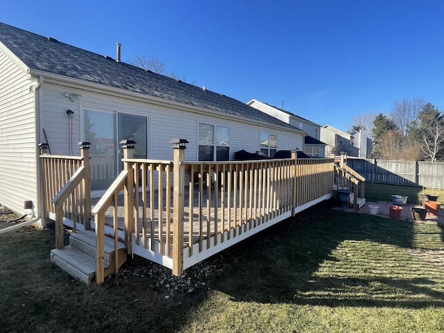 back of house featuring a lawn and a wooden deck