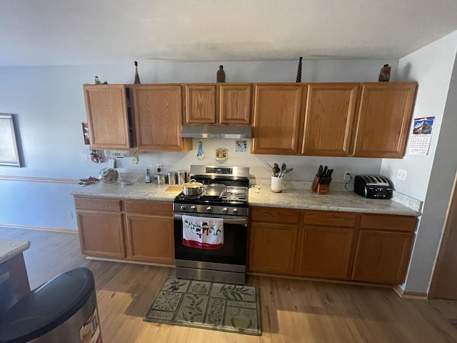 kitchen featuring light hardwood / wood-style floors and stainless steel gas range oven