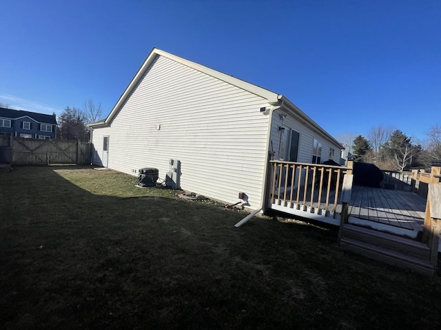 view of property exterior with a lawn and a wooden deck