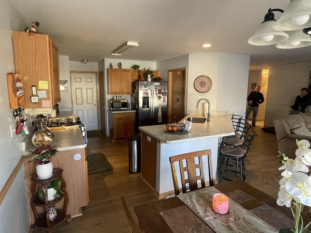 kitchen with pendant lighting, stainless steel appliances, dark hardwood / wood-style floors, and sink