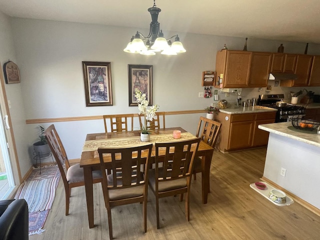 dining space featuring light hardwood / wood-style floors and an inviting chandelier