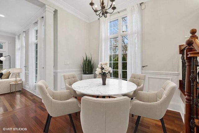 dining area with crown molding, dark hardwood / wood-style flooring, and an inviting chandelier