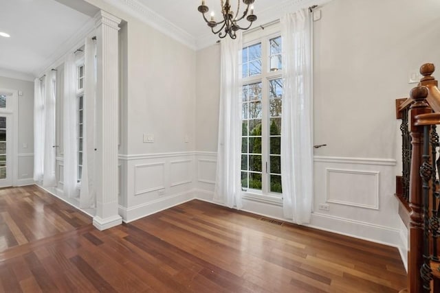 entryway with a healthy amount of sunlight, dark wood-type flooring, crown molding, and an inviting chandelier