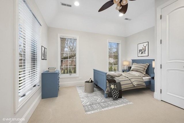 carpeted bedroom featuring multiple windows and ceiling fan