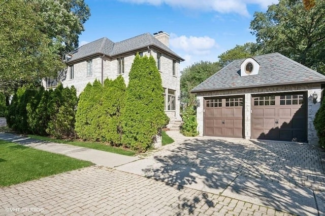 view of property exterior with an outdoor structure and a garage