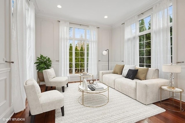 living room with plenty of natural light, wood-type flooring, and crown molding