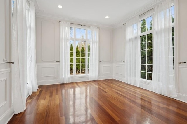 unfurnished room featuring wood-type flooring and ornamental molding