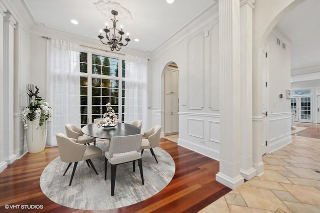 dining space featuring crown molding, hardwood / wood-style floors, and an inviting chandelier