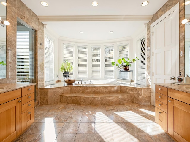 bathroom with vanity, crown molding, and a relaxing tiled tub