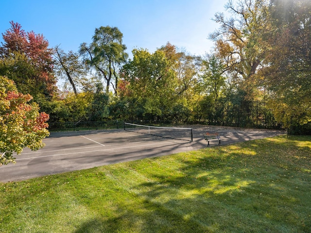 view of tennis court featuring a yard