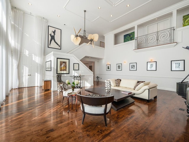 living room featuring a towering ceiling and dark hardwood / wood-style floors