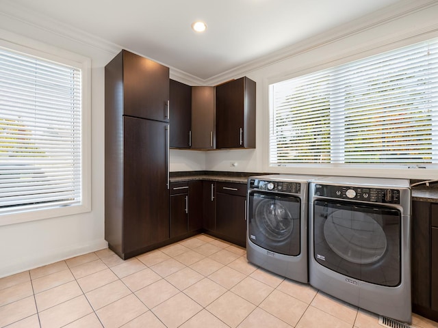 laundry area with cabinets, washing machine and dryer, ornamental molding, and light tile patterned floors