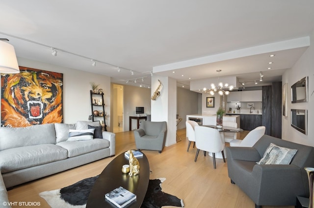 living room with a notable chandelier and light wood-type flooring