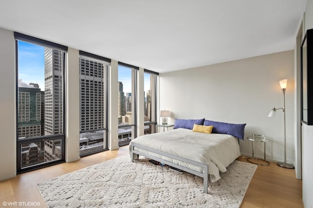 bedroom with light hardwood / wood-style flooring and expansive windows