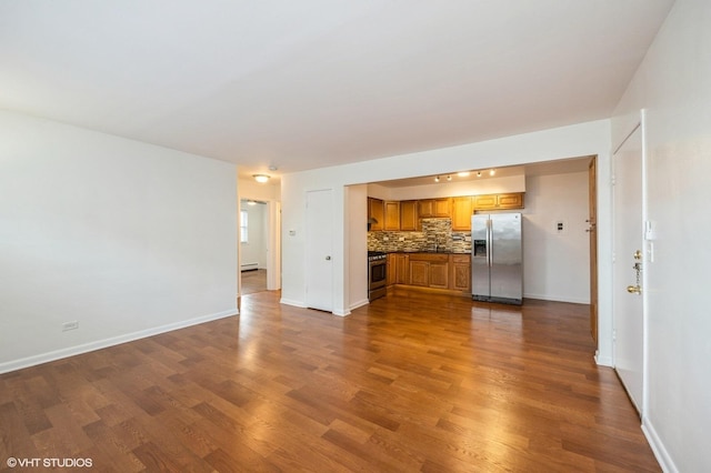 unfurnished living room featuring dark wood-type flooring and a baseboard heating unit