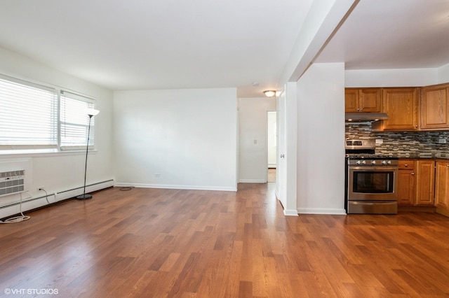 kitchen featuring stainless steel gas stove, a baseboard radiator, wood-type flooring, and decorative backsplash