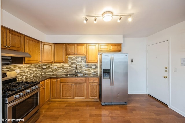 kitchen with stainless steel appliances, sink, backsplash, and dark hardwood / wood-style floors