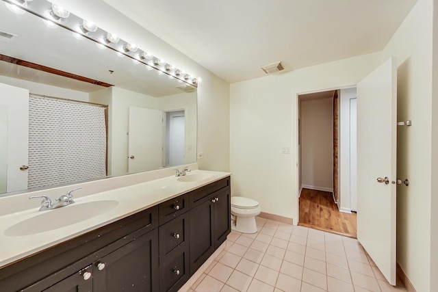 bathroom with tile patterned flooring, vanity, and toilet