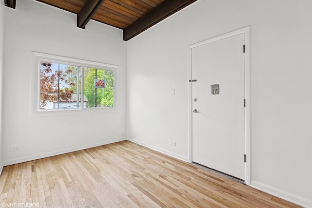 spare room with wooden ceiling, baseboards, beam ceiling, and wood finished floors