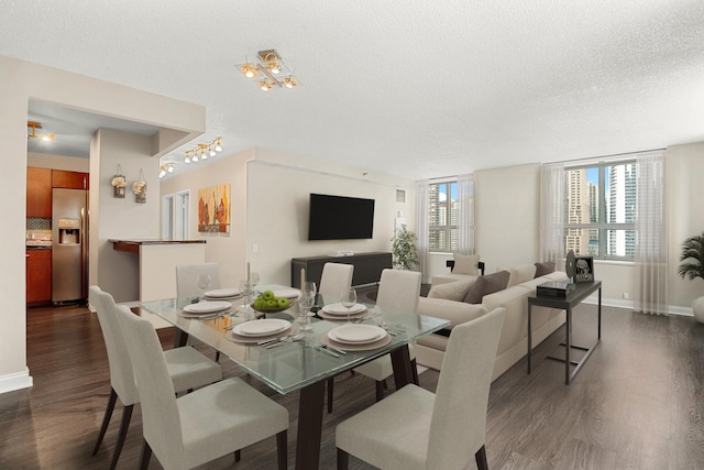 dining room with a textured ceiling and dark hardwood / wood-style floors