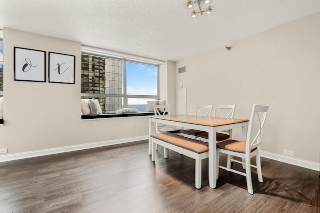 dining area with dark hardwood / wood-style flooring and a textured ceiling