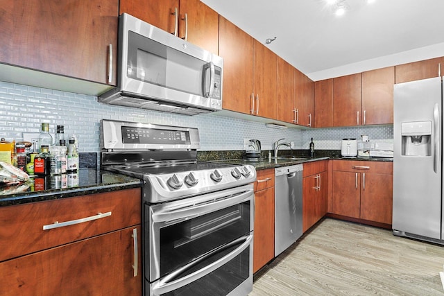 kitchen with decorative backsplash, sink, appliances with stainless steel finishes, and dark stone counters