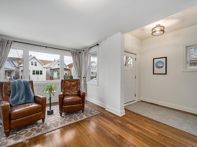 living area with a healthy amount of sunlight and dark hardwood / wood-style floors