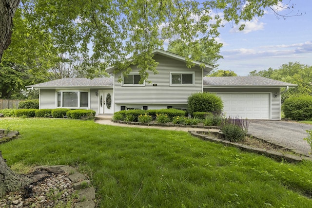 tri-level home featuring a front yard and a garage