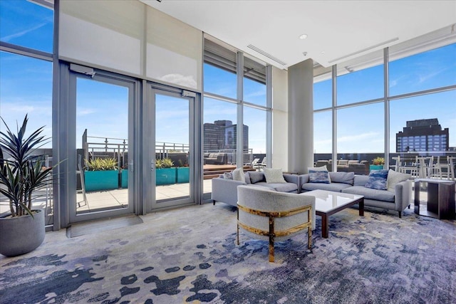 living room featuring carpet flooring, expansive windows, and a towering ceiling