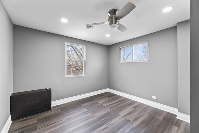 spare room featuring plenty of natural light, dark wood-type flooring, and ceiling fan