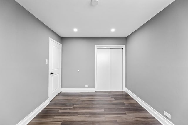 unfurnished bedroom featuring dark hardwood / wood-style floors and a closet