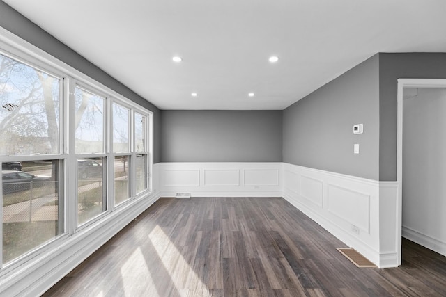 spare room featuring plenty of natural light and dark hardwood / wood-style floors