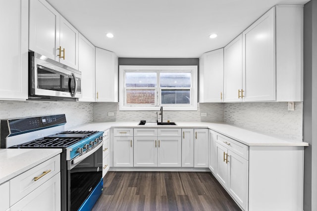 kitchen featuring white cabinets, appliances with stainless steel finishes, dark wood-type flooring, and sink