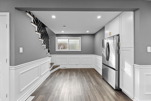 kitchen featuring stainless steel refrigerator, white cabinetry, and dark hardwood / wood-style flooring