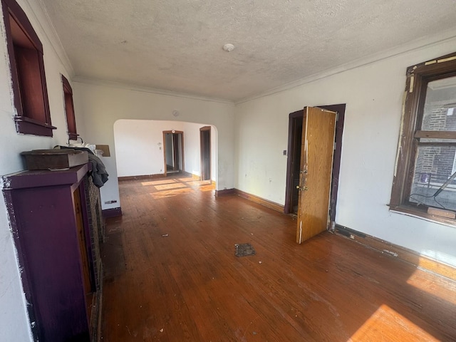 spare room featuring dark hardwood / wood-style floors, ornamental molding, and a textured ceiling